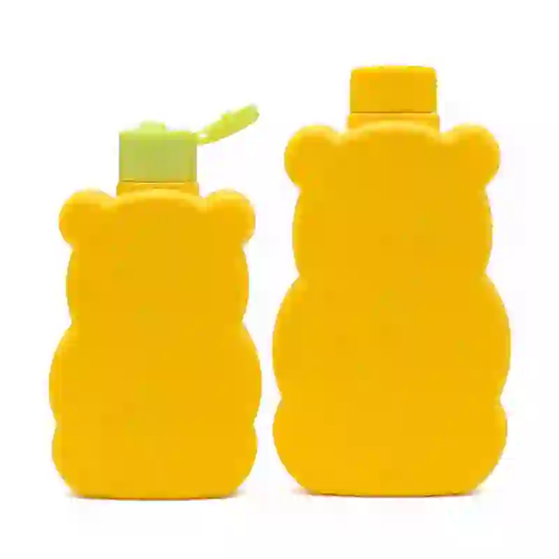 factory supply of flat bear-shaped yellow HDPE bottles, featuring a small bottle with a light green flip cap and a large bottle with a silver aluminum screw lid.