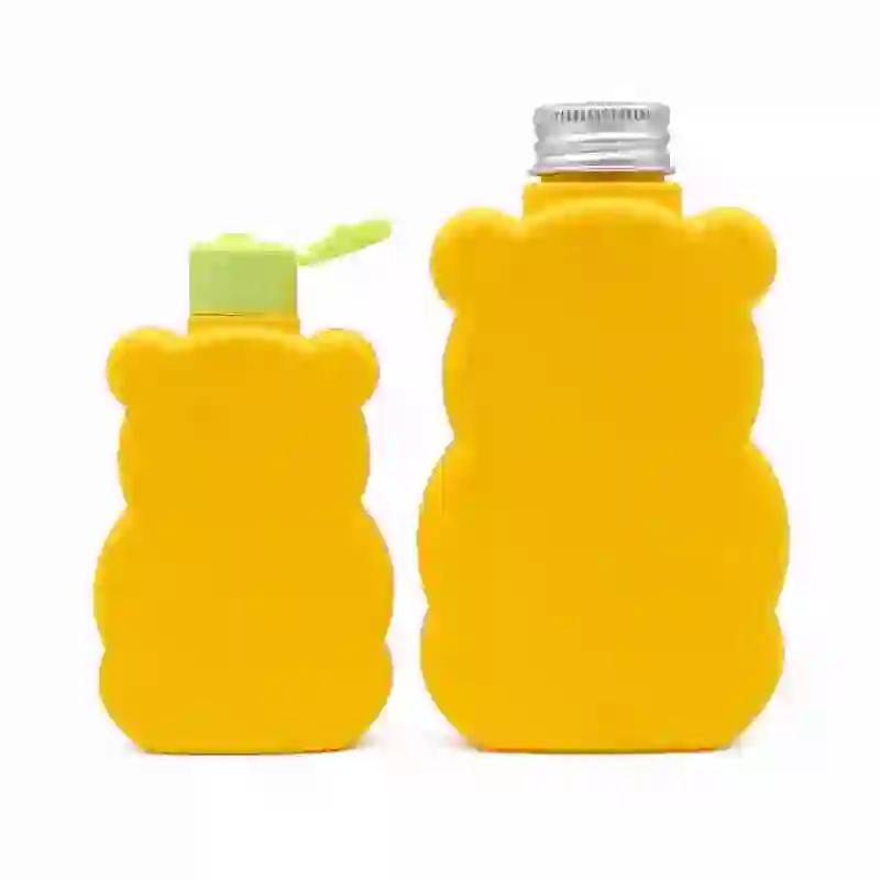 custom yellow bear-shaped HDPE plastic bottles, showing one mini bottle with a green flip-top cap and a larger bottle with a ribbed screw closure for kids liquid soap.